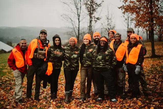 HOC members in the field wearing an orange vest.